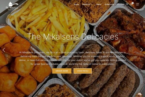 The Mikalsens Delicacies restaurant homepage showcasing fried chicken, chips, and various prepared meals in takeaway containers.