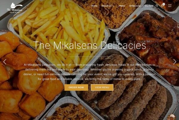 The Mikalsens Delicacies restaurant homepage showcasing fried chicken, chips, and various prepared meals in takeaway containers.